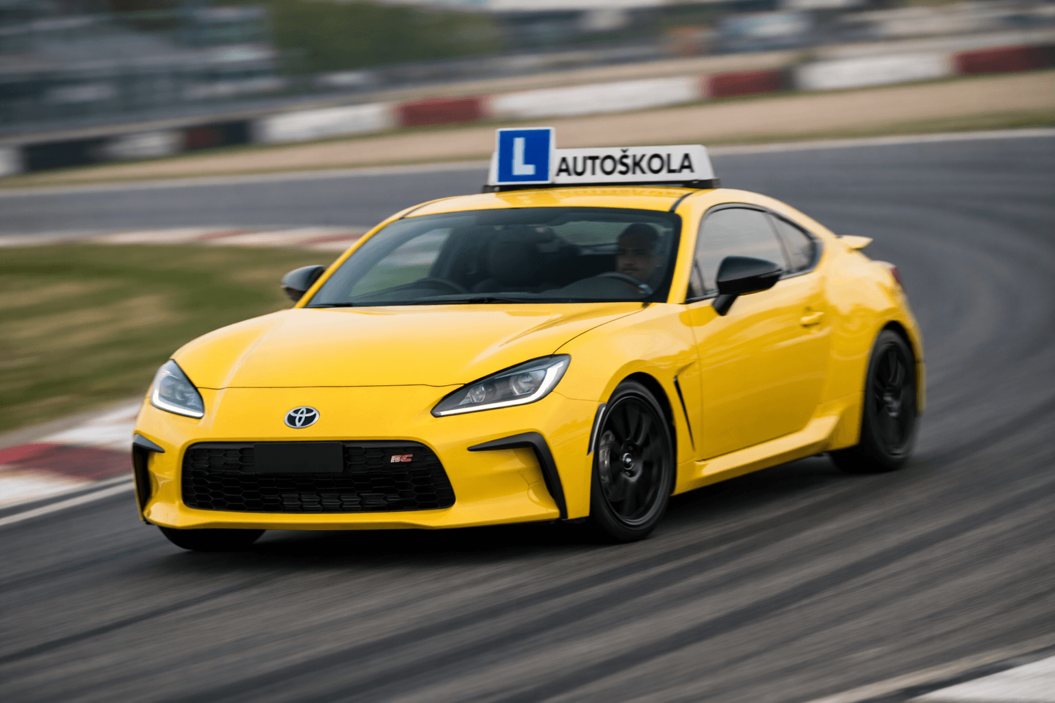 A yellow Drive4Life Toyota GR86 driving through a corner on a racing circuit.